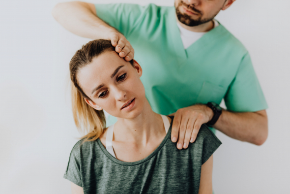 Man examining a woman's neck during a chiropractic session